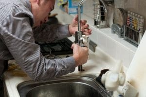 Plumber working on faucet