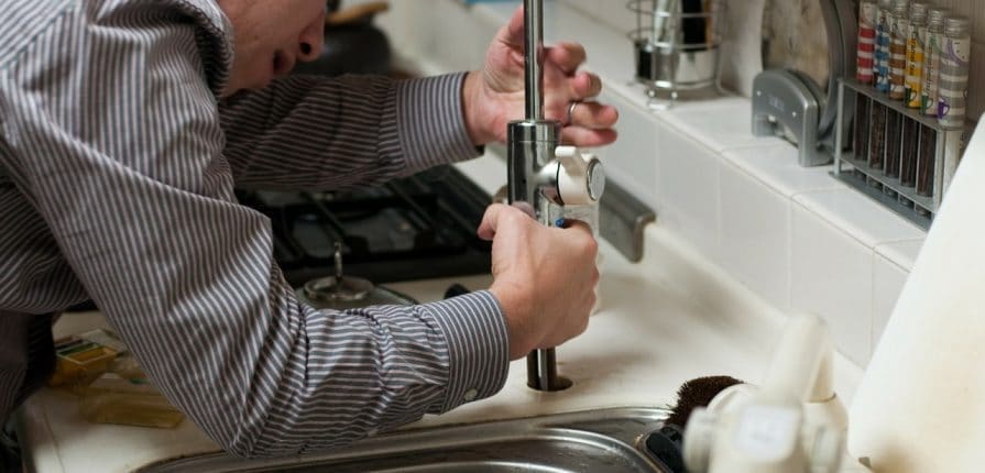 Plumber working on faucet
