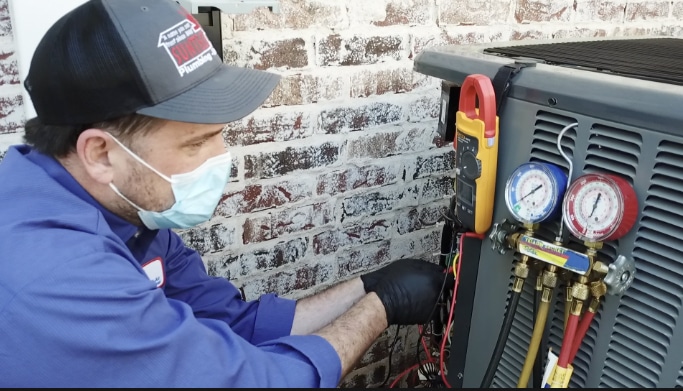AC repair technician servicing an outdoor air conditioner.